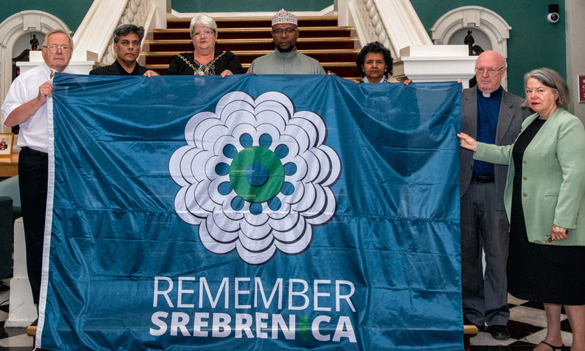 The Mayor and faith leaders with a Remembering Srebrenica flag.