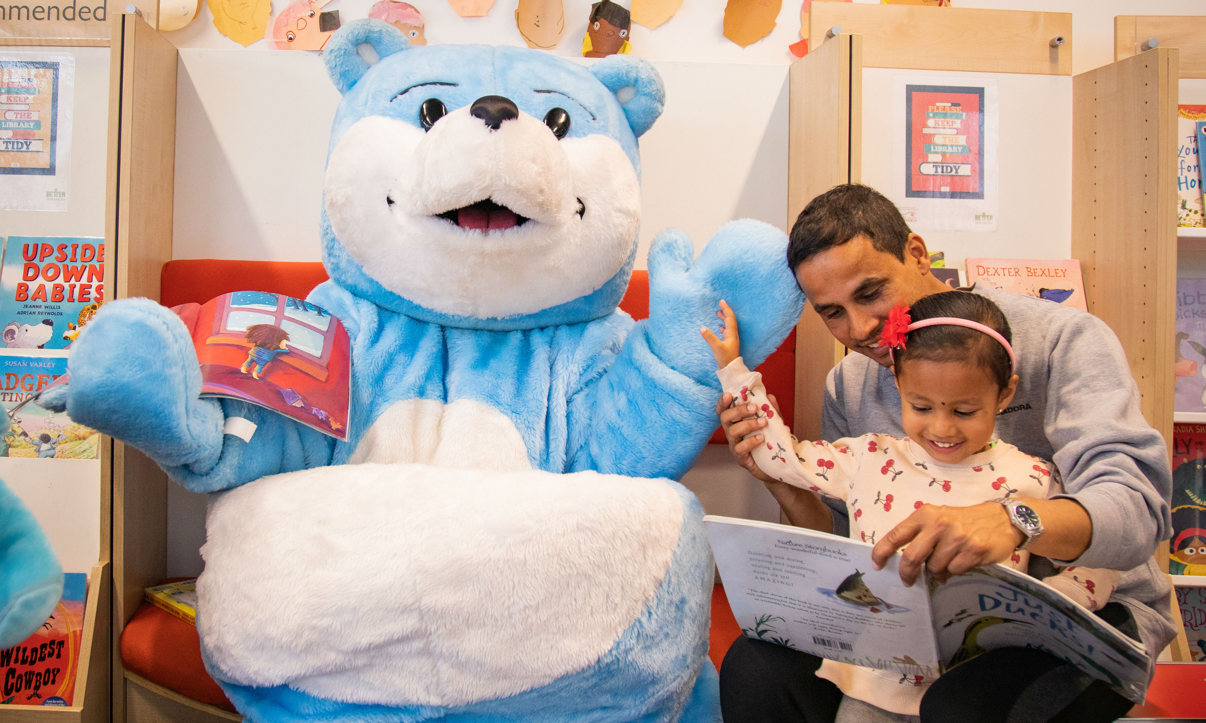 Child and father reading with Blue Bear,