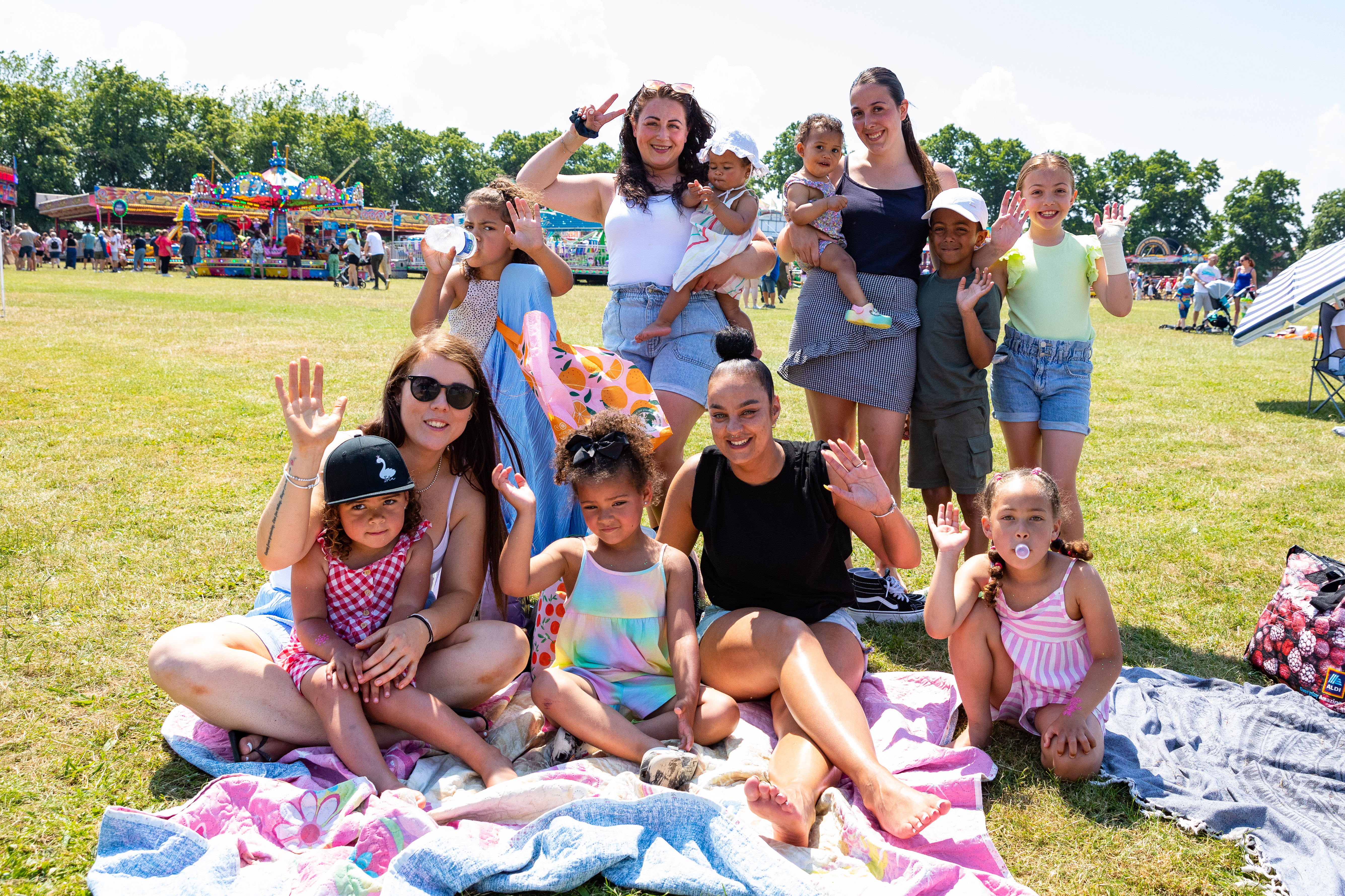 A group of people at Together 23 on a picnic blanket, smiling at the camera