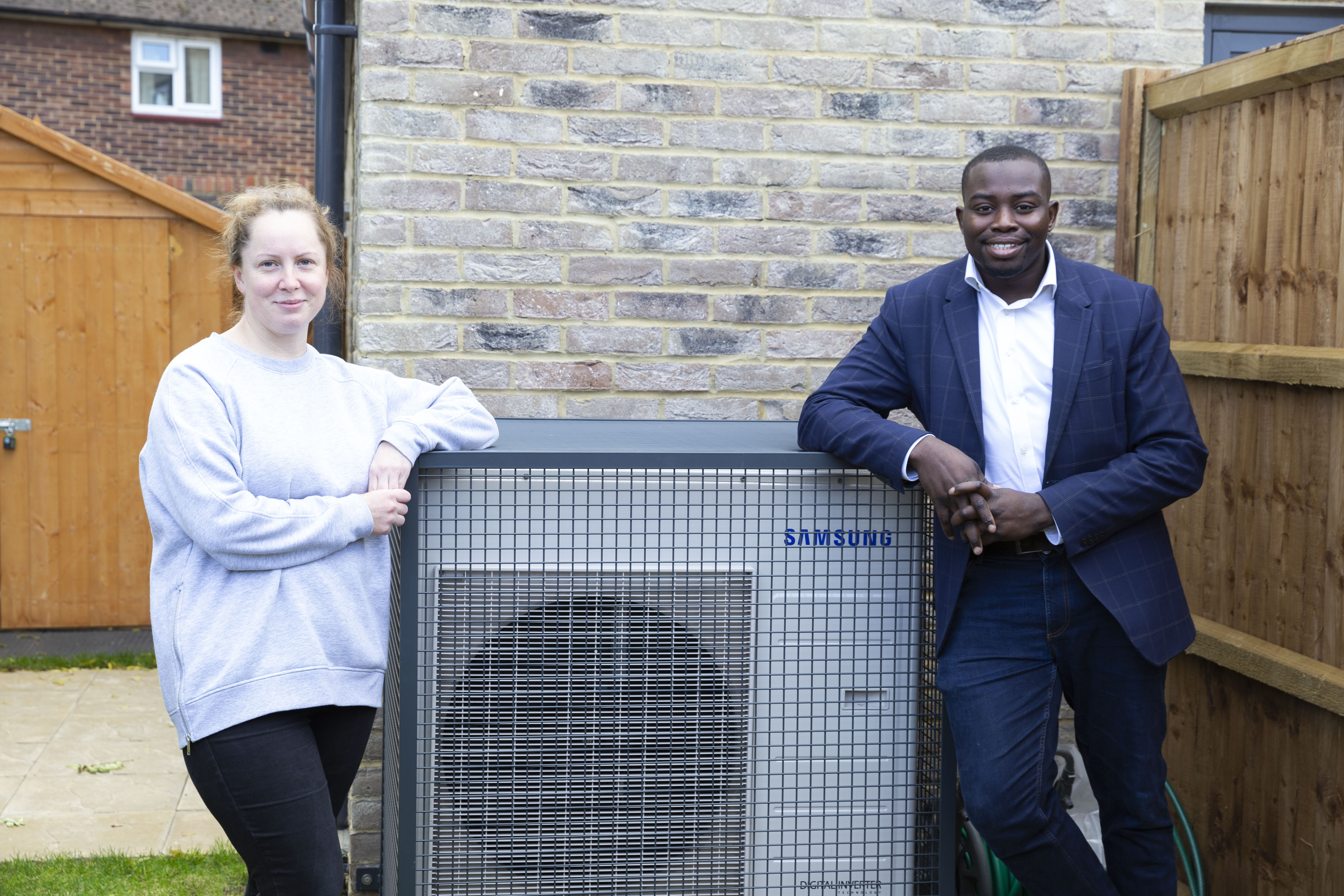 Cllr Anthony Okereke and Greenwich Builds tenant Ginta with a heat pump fan