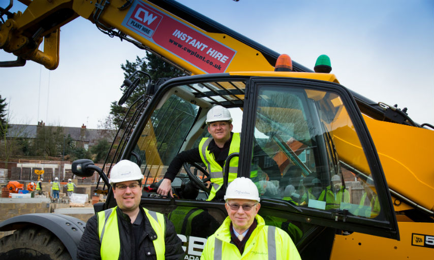 Councillor Thorpe, Councillor Kirby &amp; Richard Reynolds from Meridian Home Start pictured around a yellow tractor at Woodpecker Gardens construction site