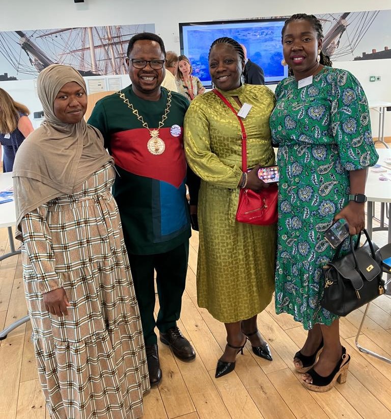 The Mayor of the Royal Borough of Greenwich, Cllr Dominic Mbang posing for a photo with three women, who are from some of the projects who received grant funding.