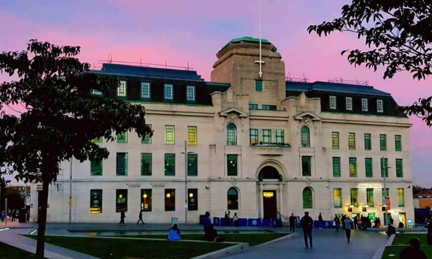 Picture of Equitable House on General Gordon Square, behind a pinkish blue skyline.