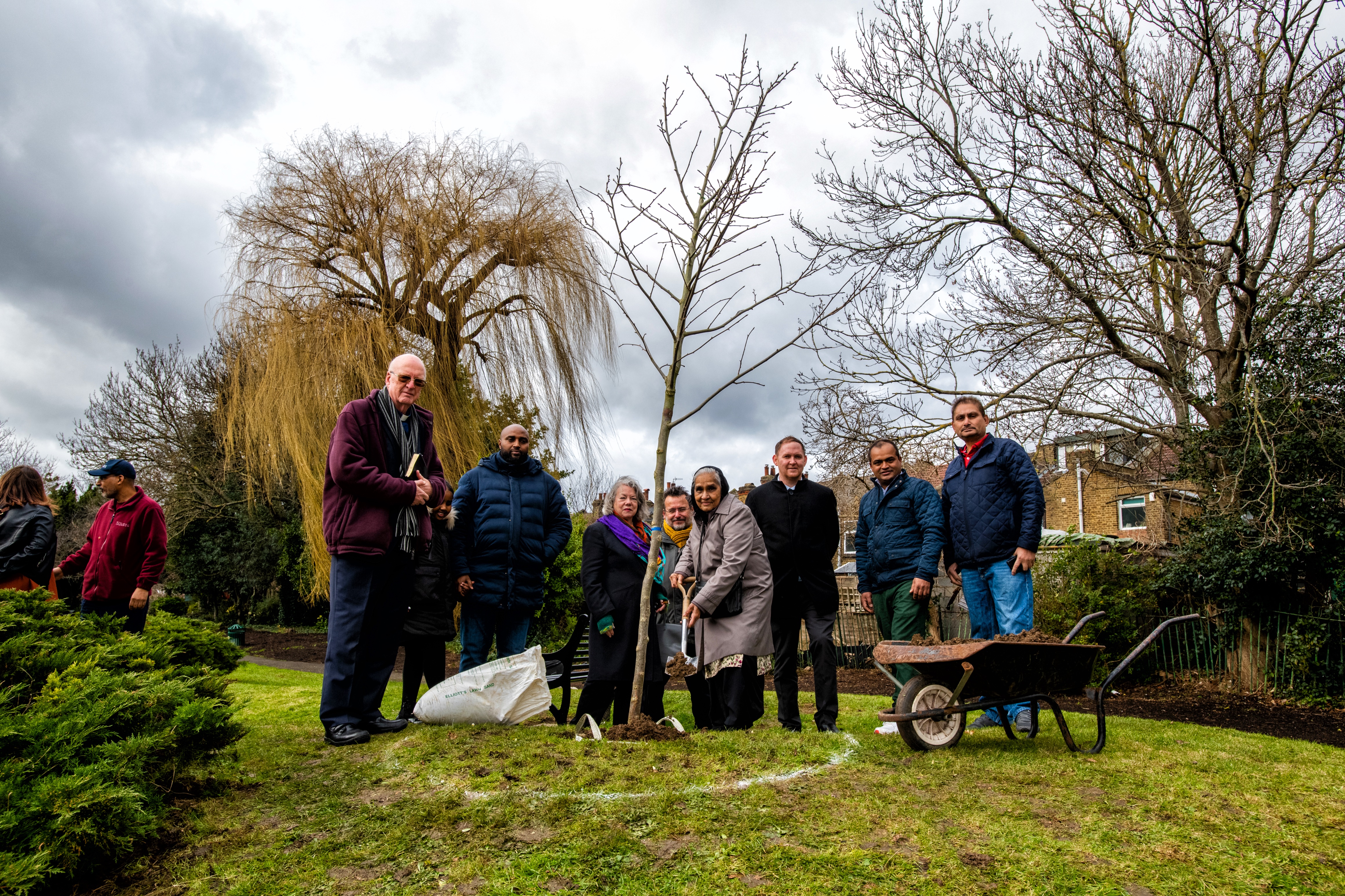 L-R Reverend Mike, Cllr Adel Khaireh, Cllr Angela Cornforth, Members from Friends of Parks and Cllr Danny Thorpe standing infront of the COVID memorial tree in Plumstead Gardens.