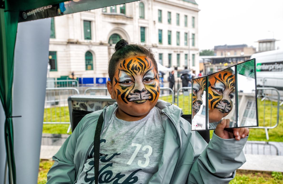 A child shows off her tiger face paint