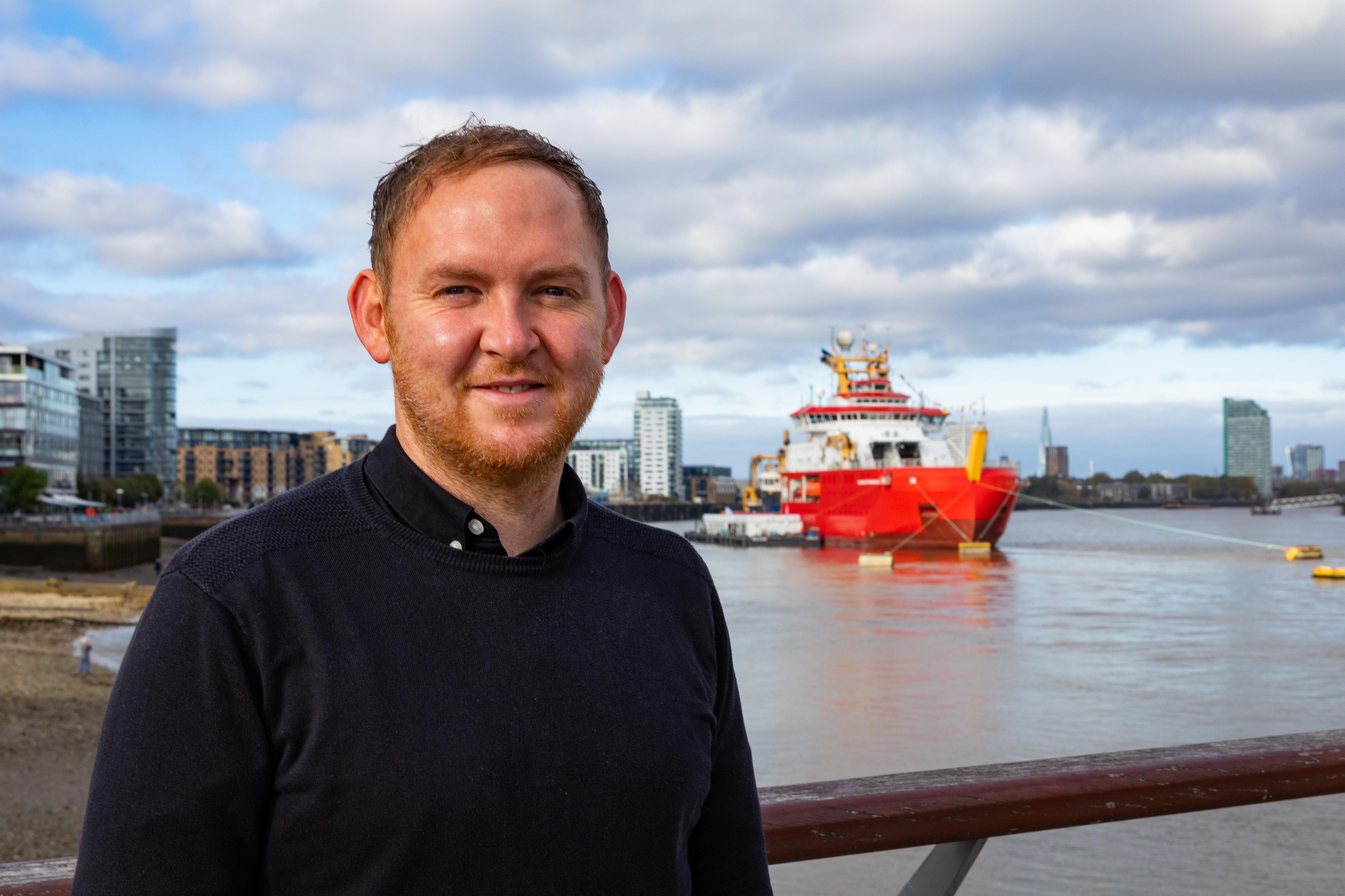 Danny Thorpe stands in front of the RRS Sir David Attenborough, during its stop in Greenwich on the way to Antarctica.