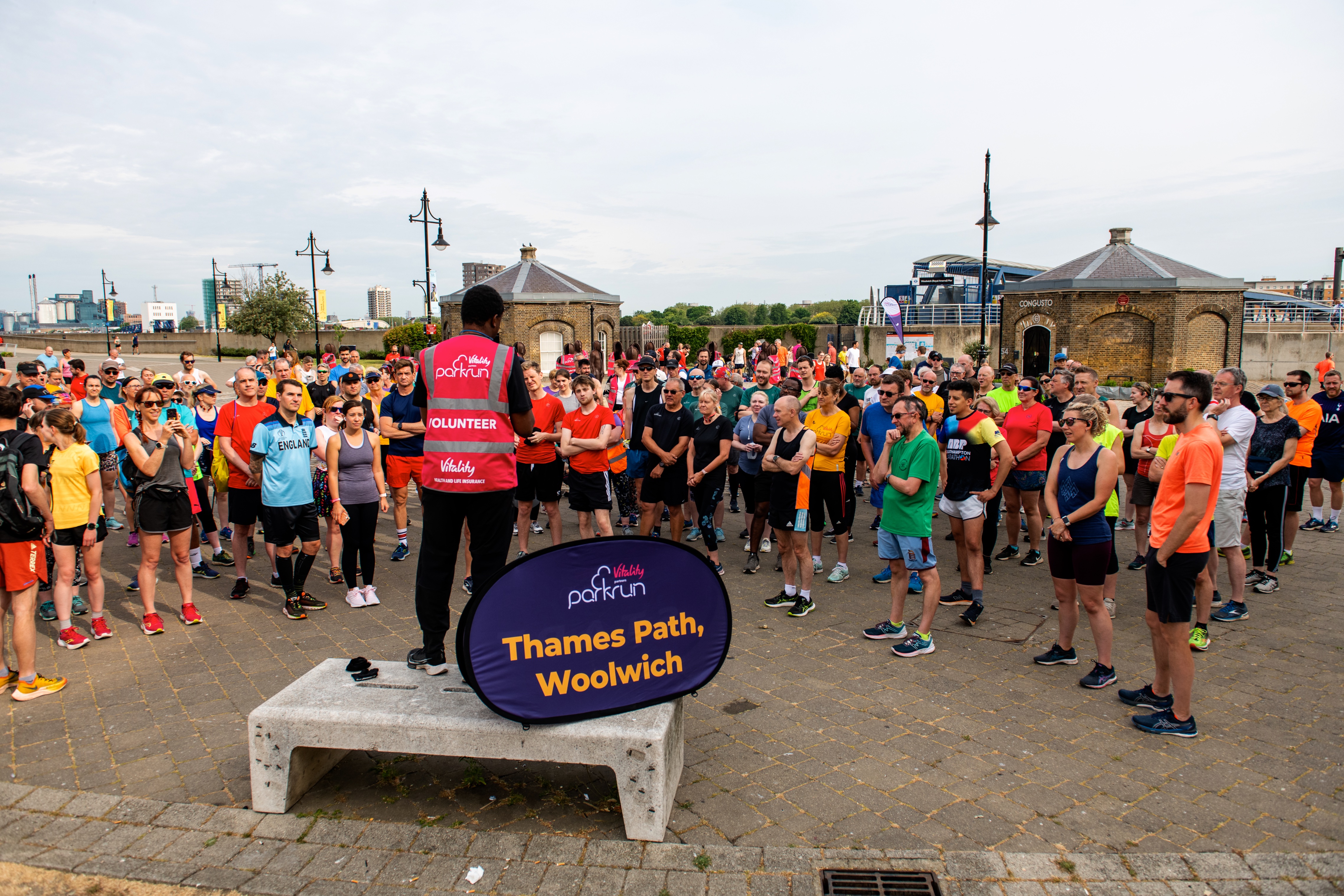 A crowd of parkrunners receive a  briefing