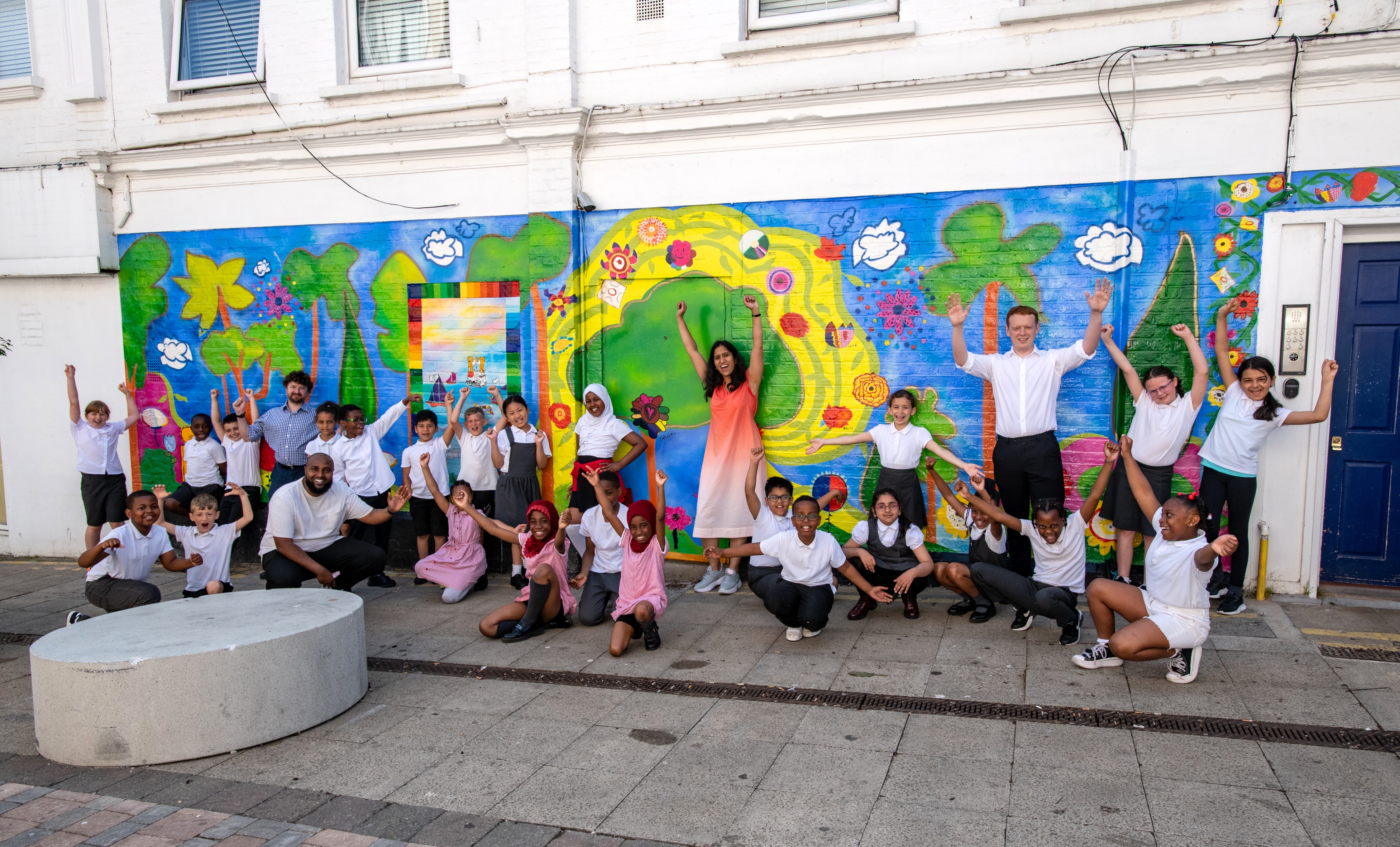 Pupils from Nightingale Primary School with Cllr Adel Khaireh, Cllr Aidan Smith, Cllr Sam Littlewood and artist Haffeera Cader Saul unveiling a mural on Barnard Close