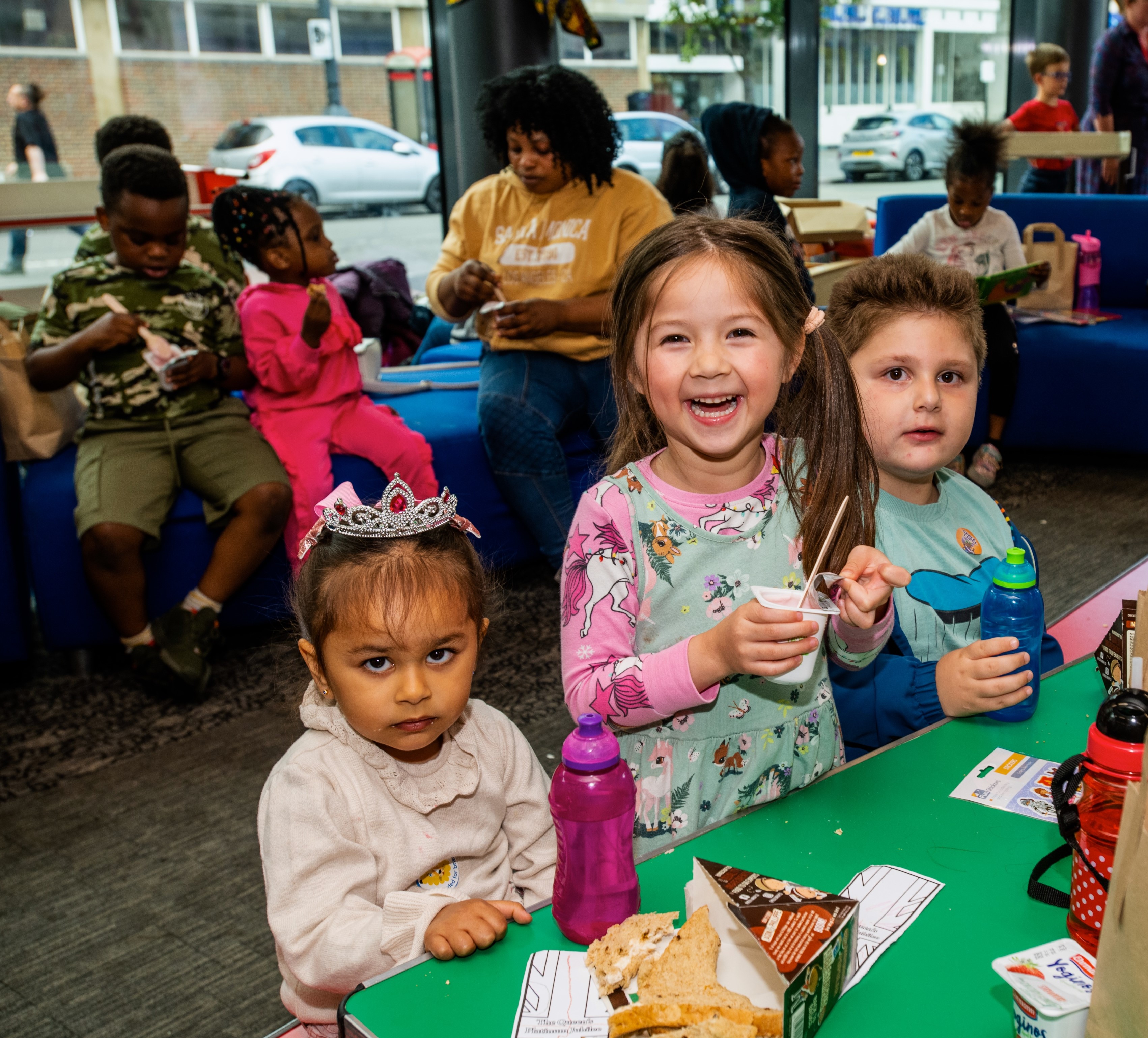 Three children enjoying free holiday meals at a local library