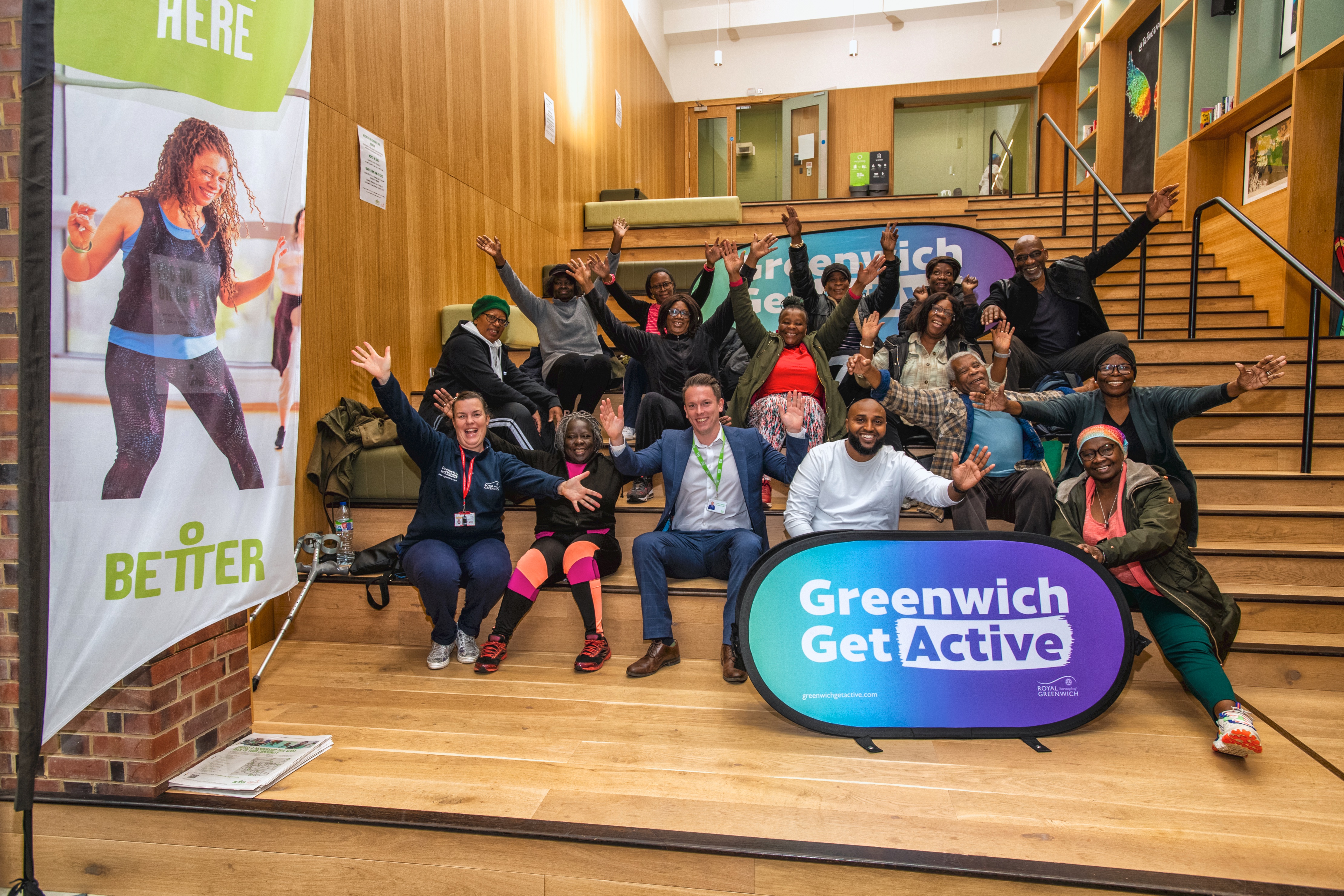 Group of people cheering as they sit on the steps at The Plumstead Centre