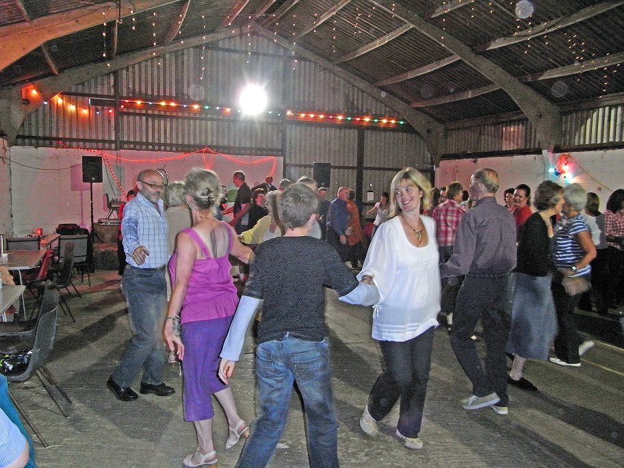 A group of people dancing in a barn
