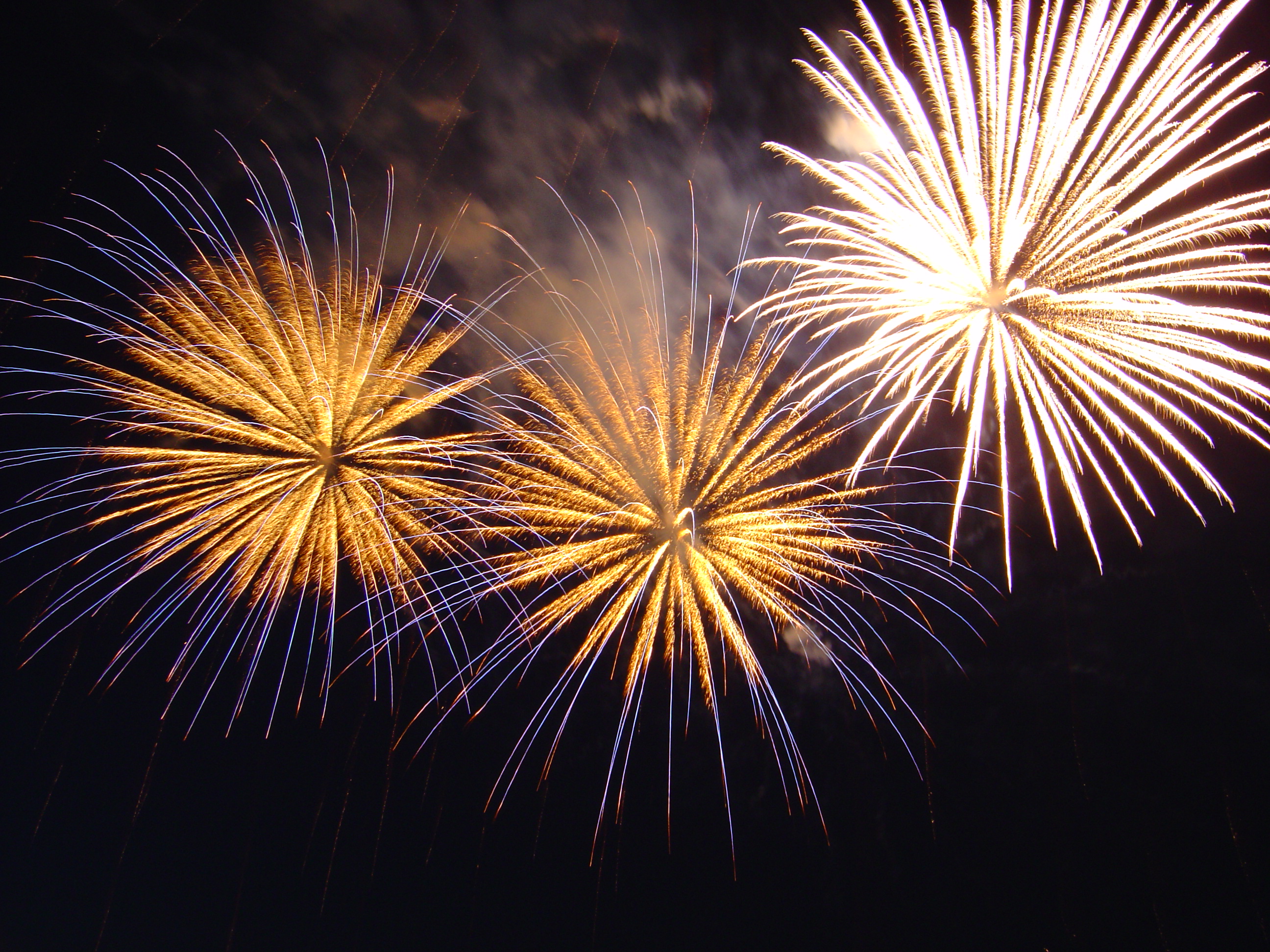 Fireworks display of yellow and white bright light against the dark night's sky.