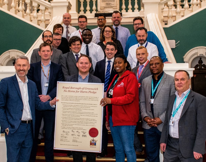 Cllr Danny Thorpe, Cllr Chris Kirby, Cllr Jackie Smith and representatives from L&Q, Optivo, Southern Housing Group, PA Housing, Charlton Triangle Homes, Peabody, Hexagon and Moat, posing and holding the pledge on the town hall steps.