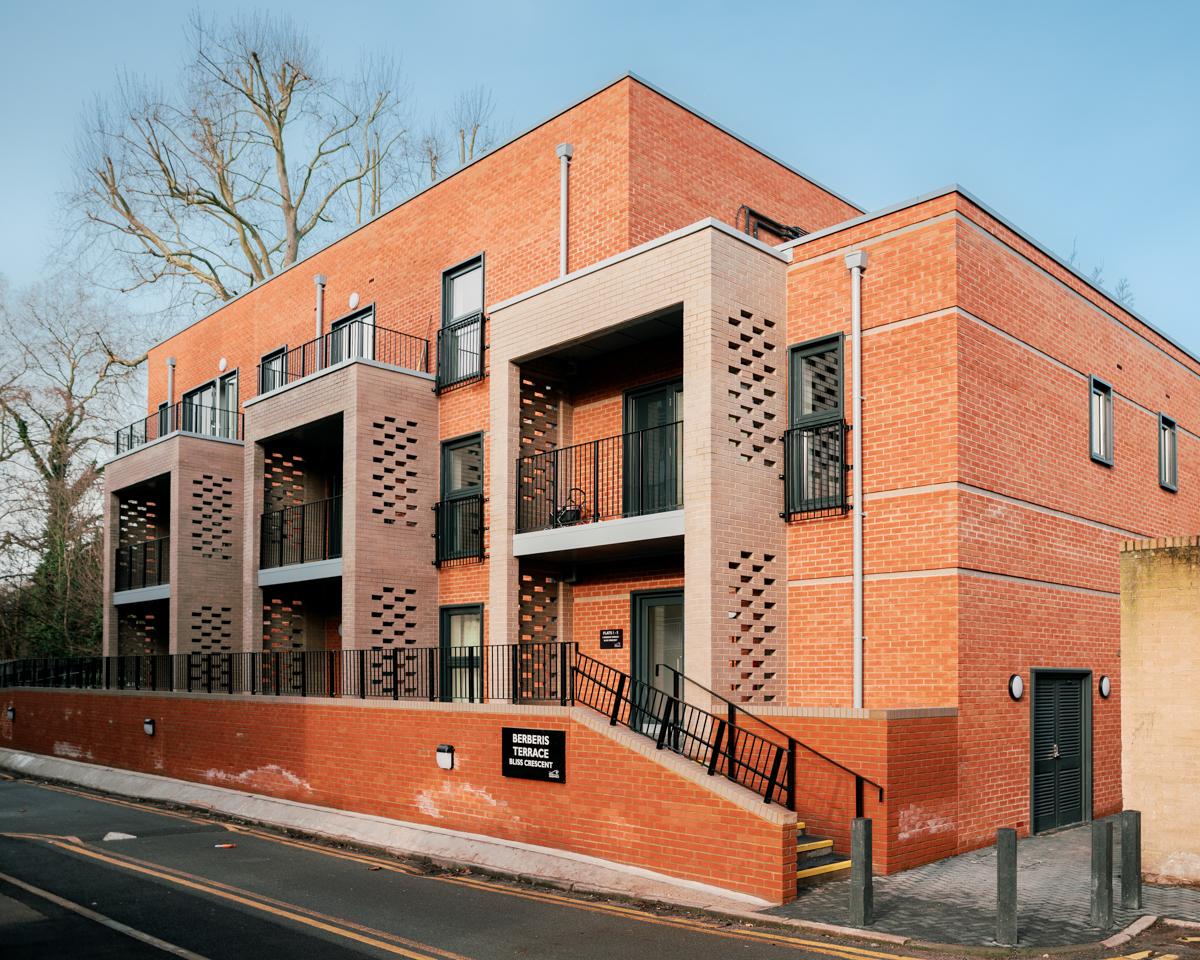 The new development of council apartments at Bliss Crescent, in a single three-storey block with a modern red brick design and balconies in brown brick.