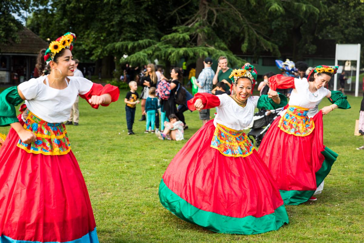 A photo of dancers in colourful dress performing at a Royal Greenwich Festivals event.