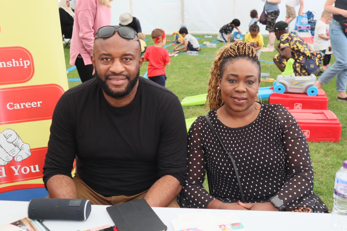 Two people sat behind a table at an outdoor event