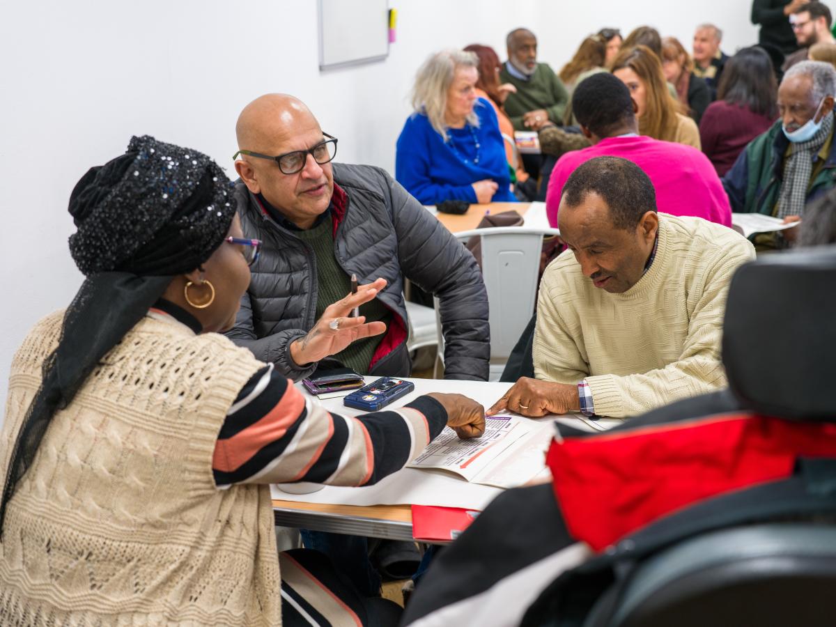 Residents gathered about a table having a discussion