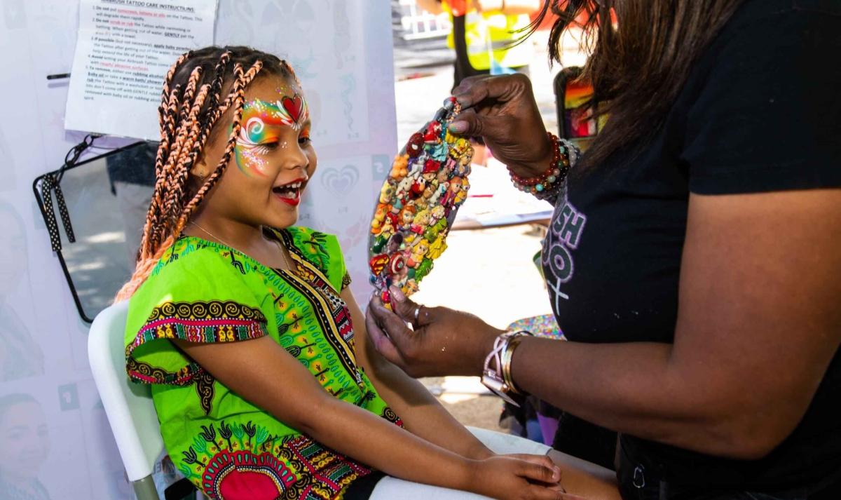 A little girl getting her face painted 