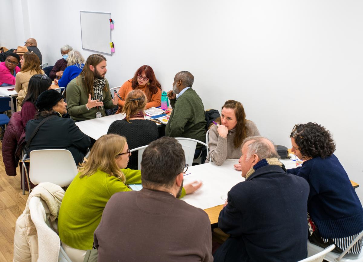 Residents gathered about a table having a discussion