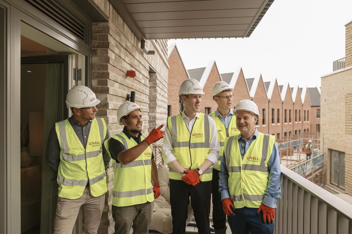 Councillor Majid Rahman with housing minister Matthew Pennycook (both centre of the image) at Woolwich Estates