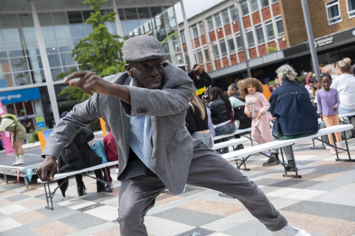 A man dancing in a public square outdoors.