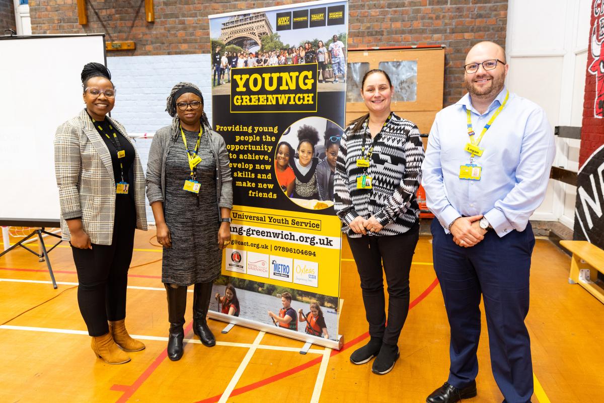 Staff working within Young Greenwich stood in front of a banner promoting the service.