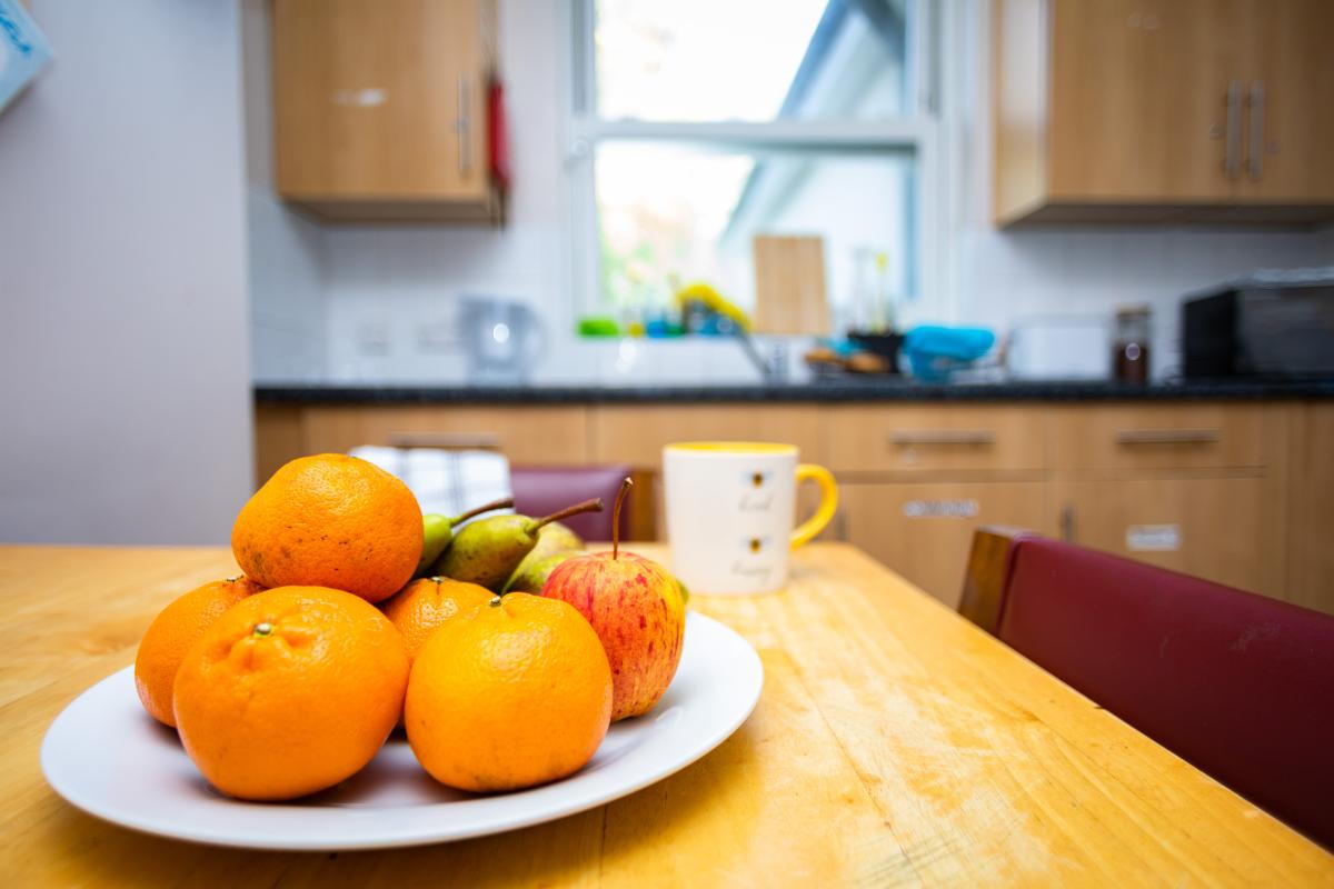 a plate of oranges on a kitchen table in a temporary accommodation unit