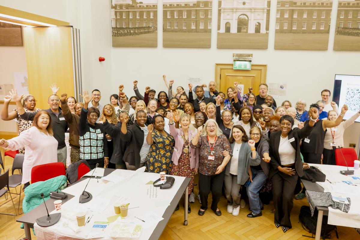 Image showing attendees of the event smiling and cheering as they pose for a group photo