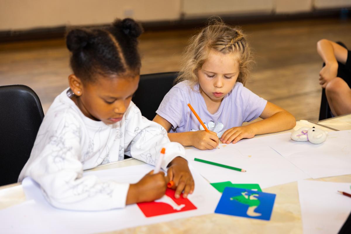Two kids drawing in an indoor space