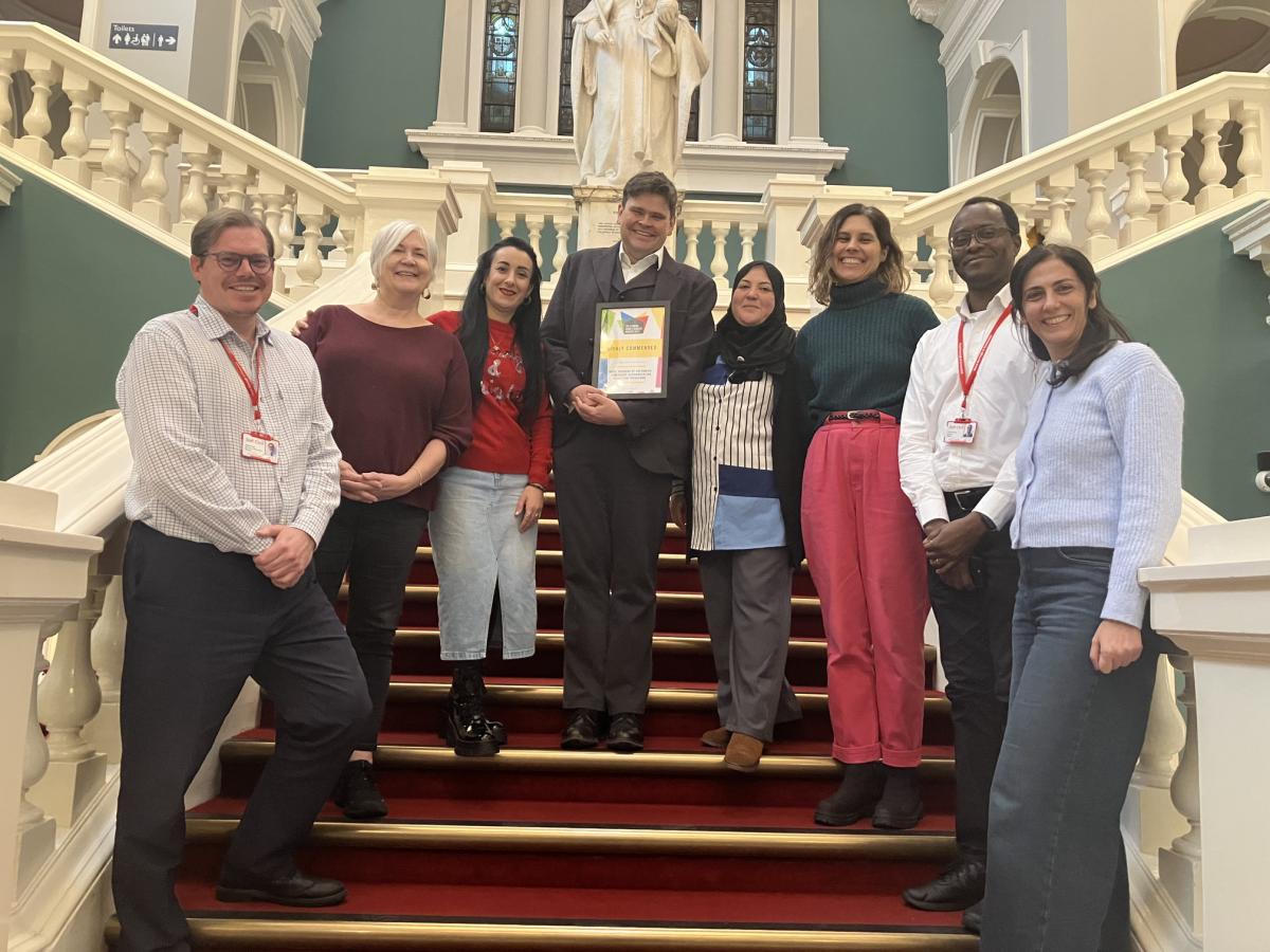Group of staff and members of Creating Ground with their certificate of commendation on the steps of the Town Hall. 