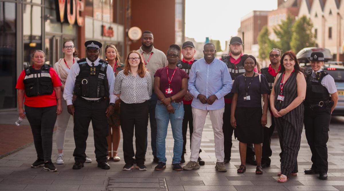 A group of council staff, Councillors and police officers stand for a group photo.
