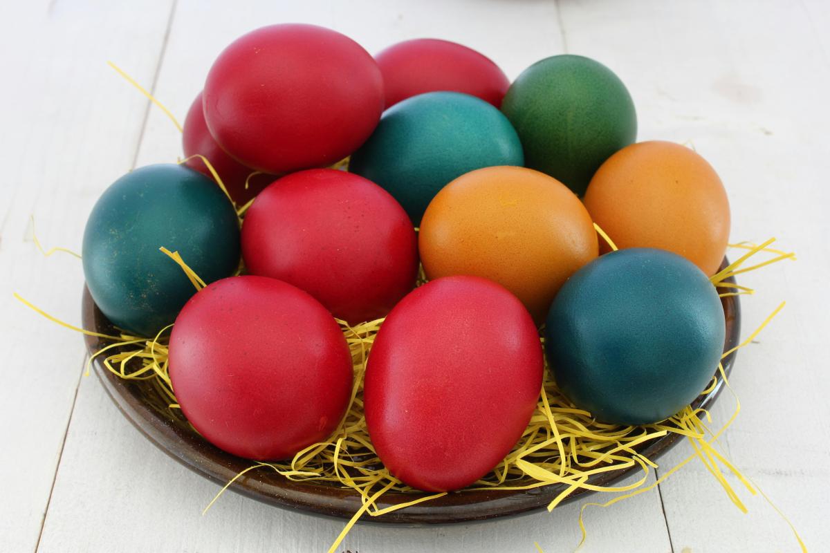 bowl with painted eggs coloured red, yellow and green