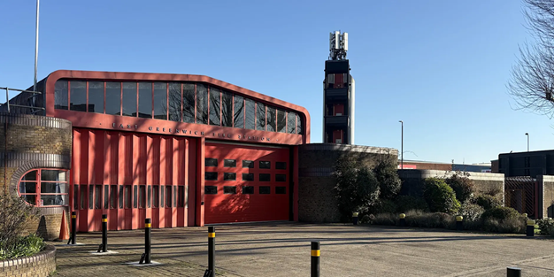 front of the firestation building in east greenwich with large red shutters that are closed