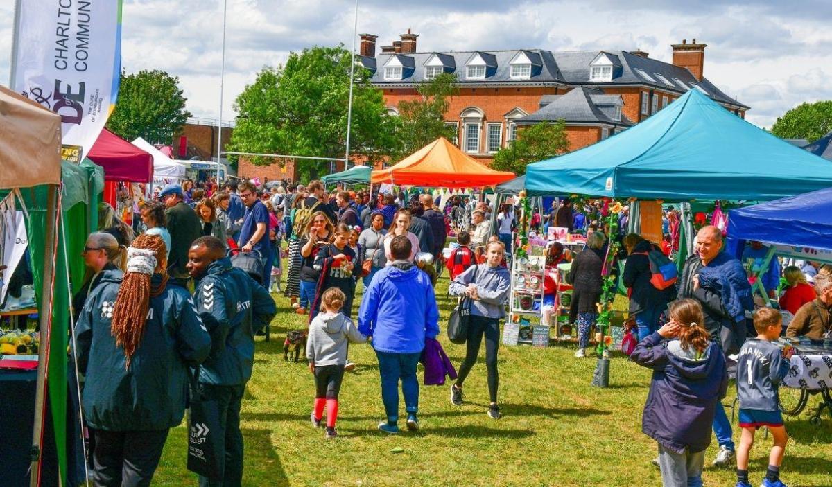 A busy market scene with colourful tents and crowds of people