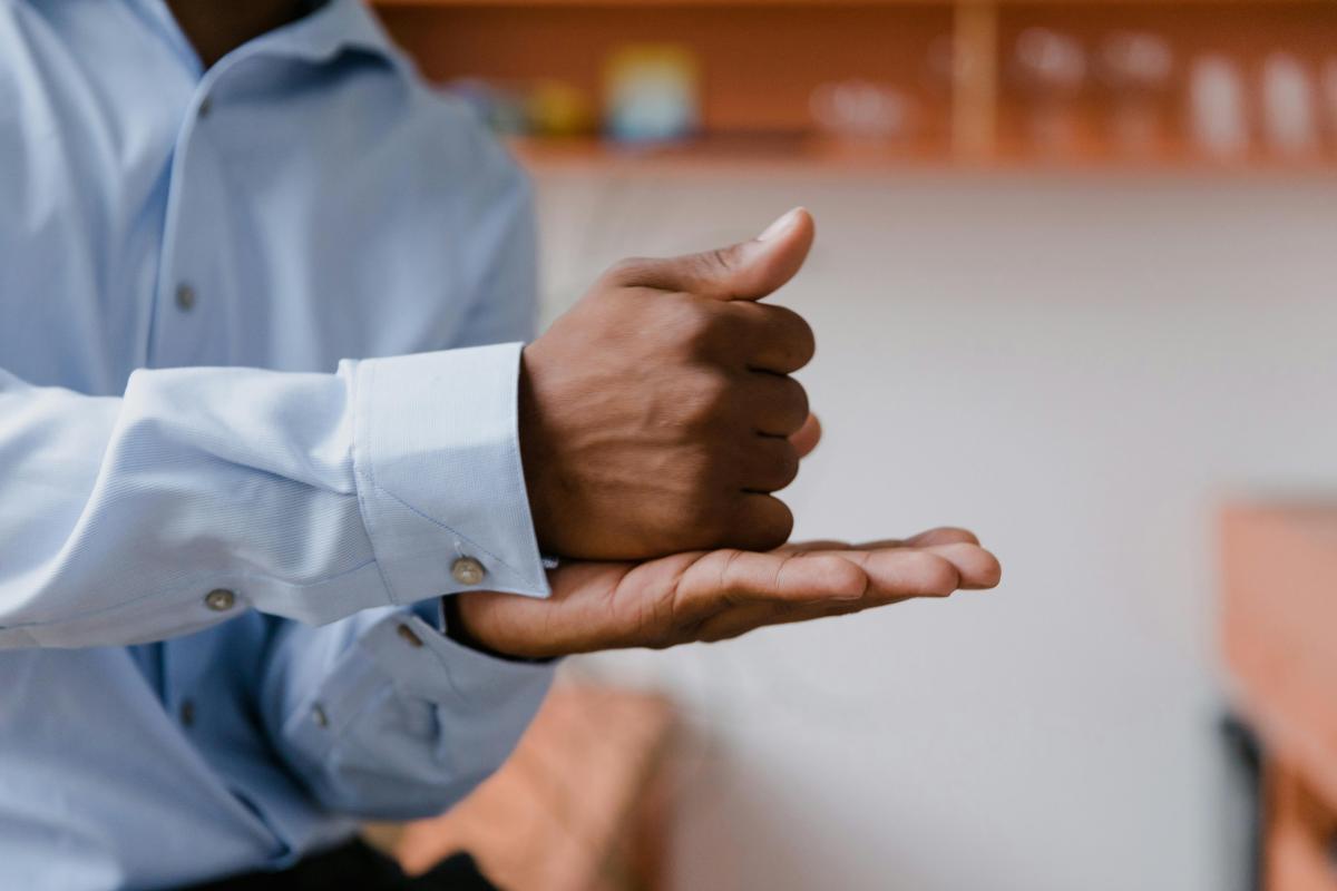 two hands, one flat out with palm up and the other is a fist that is sitting on top of the palm of the other hand