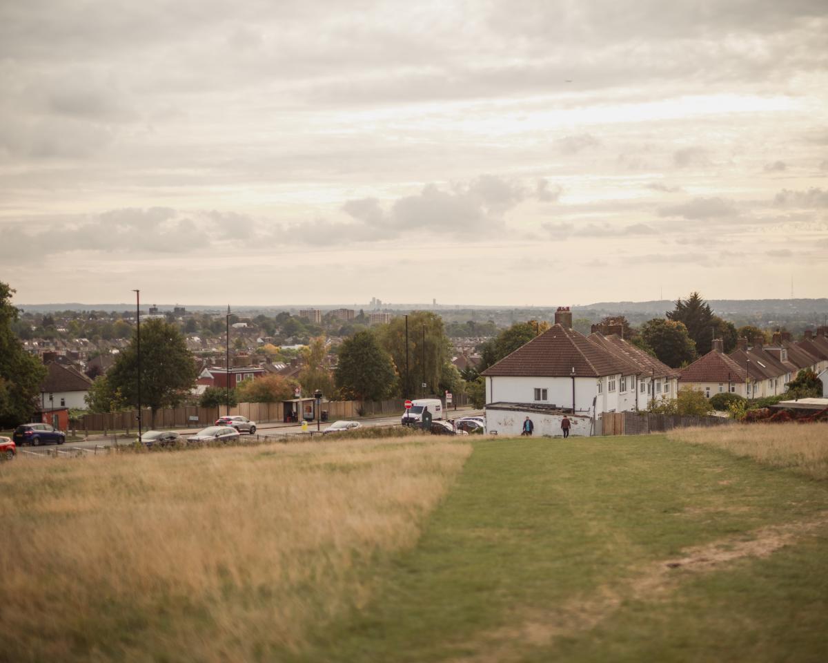 Fields with buildings and a road in the background.