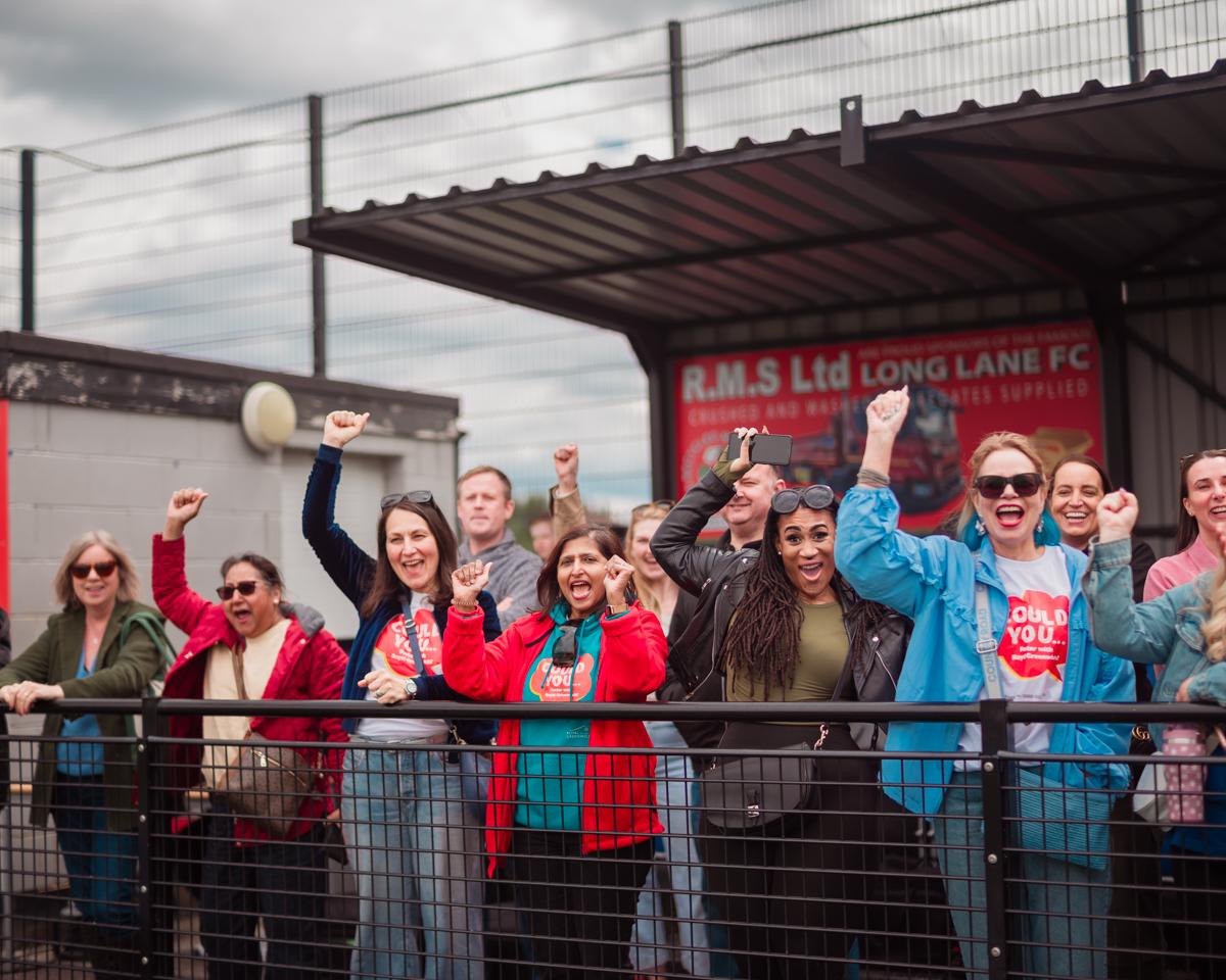 A crowd of people inside a football ground cheering