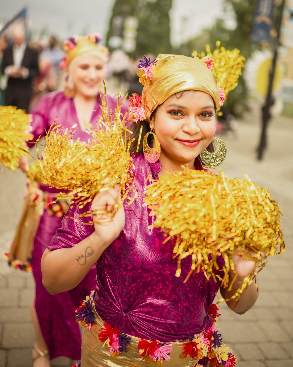 Dancers in a carnival parade wearing pink and gold clothing