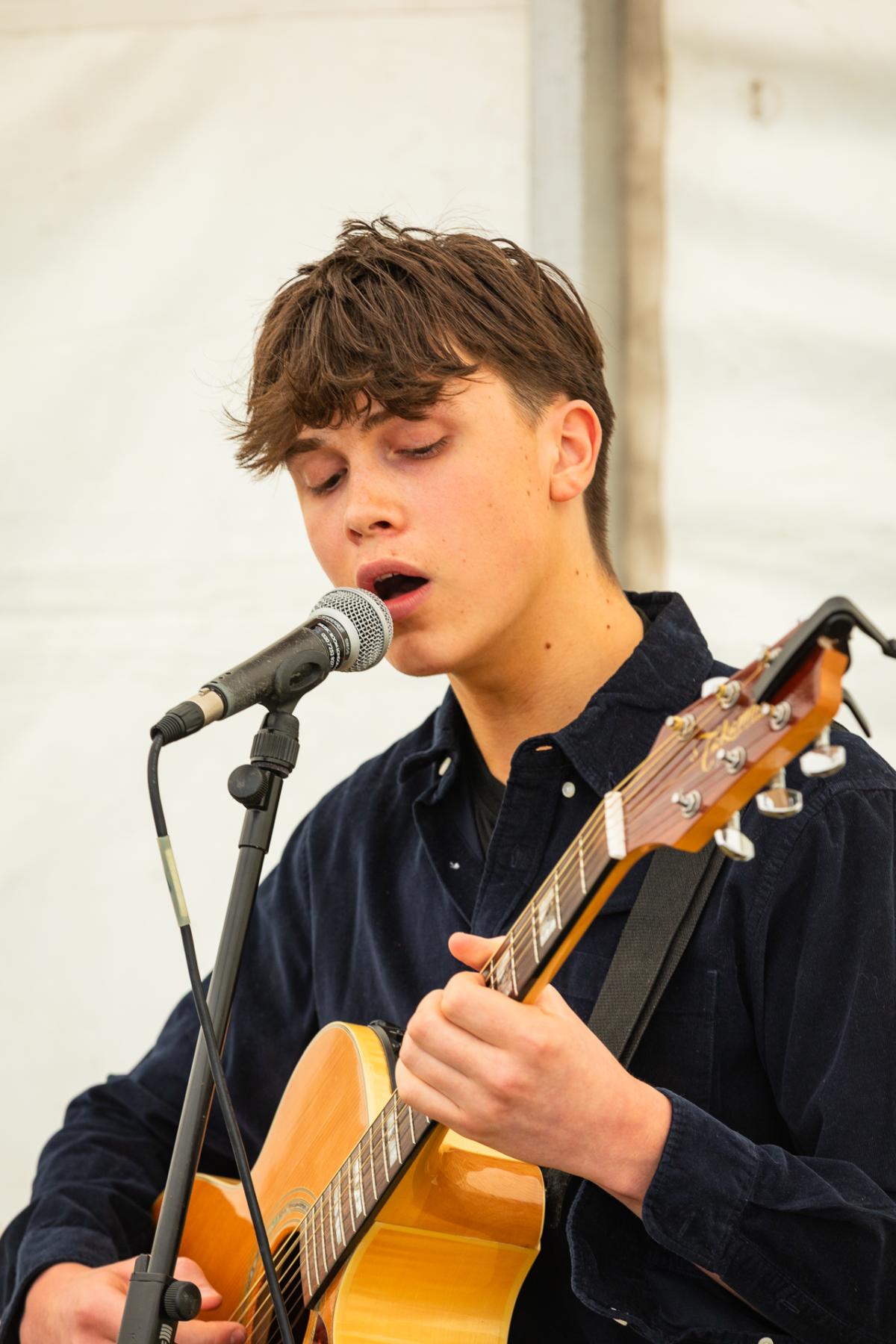A person playing guitar and singing into a microphone