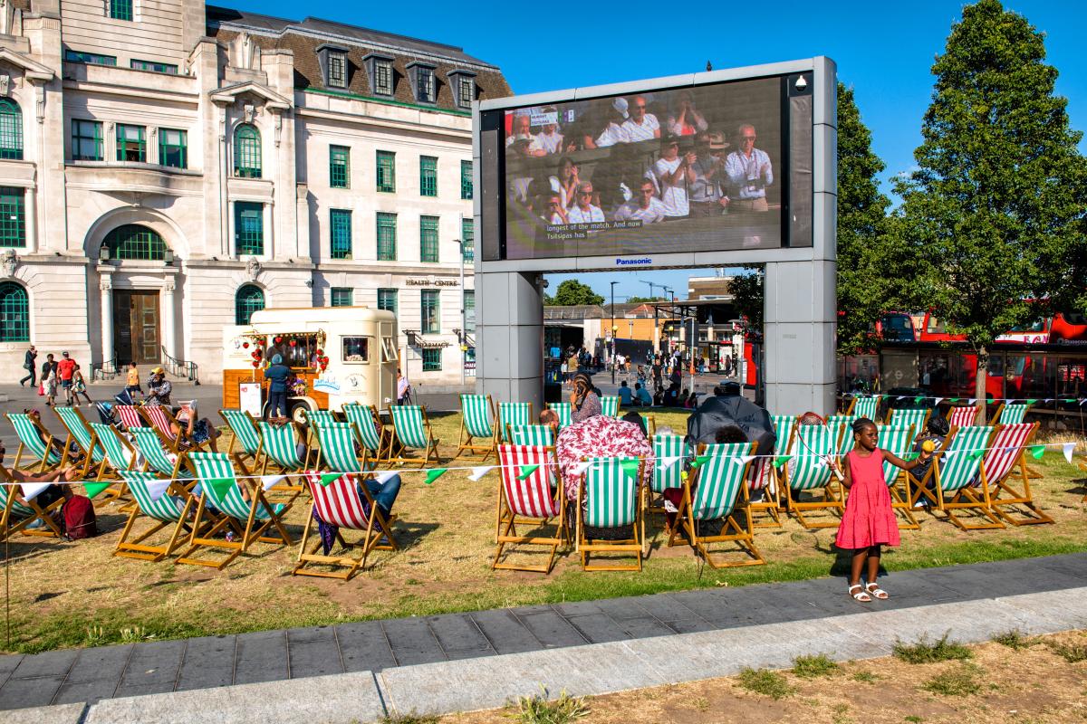 Outdoor public viewing area in General Gordon Square with striped deck chairs facing the Big Screen showing a tennis match on a sunny day.