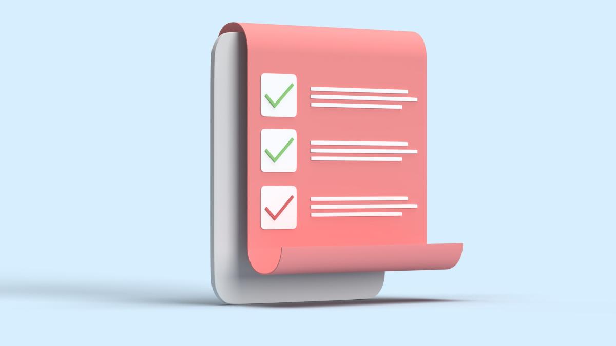 an upright grey paperholder with a red piece of paper with tick boxes draped over it
