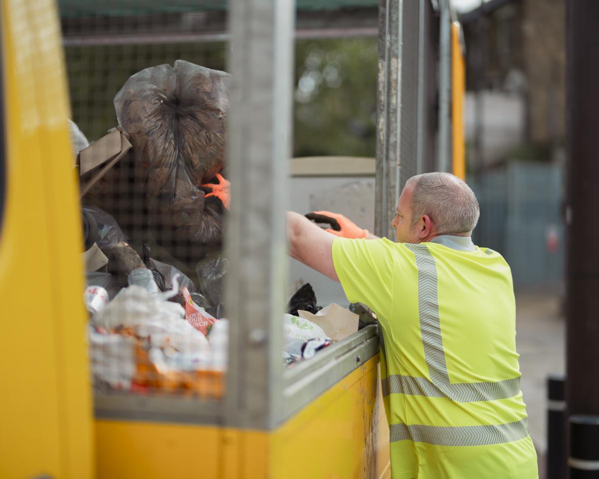 Staff in high-vis cleans up fly-tipped waste