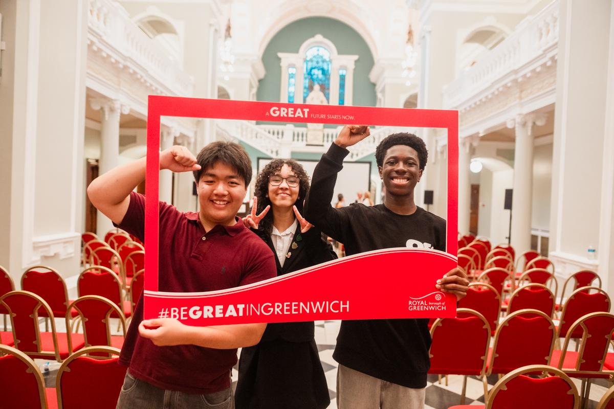 Three students celebrate with hand raised in a selfie frame for Great in Greenwich