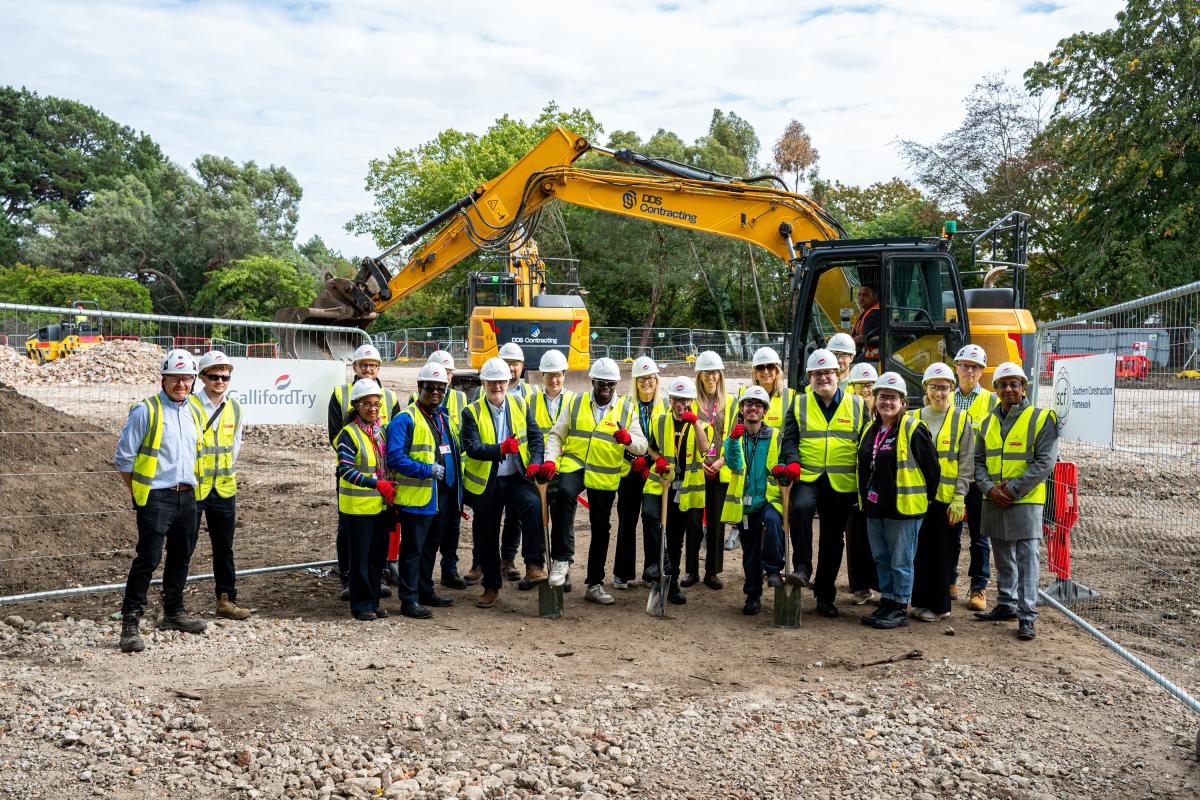 Group photo of cllrs and representative from Galliford Try Lsec Royal Greenwich in hard hats and high viz with a digger in background
