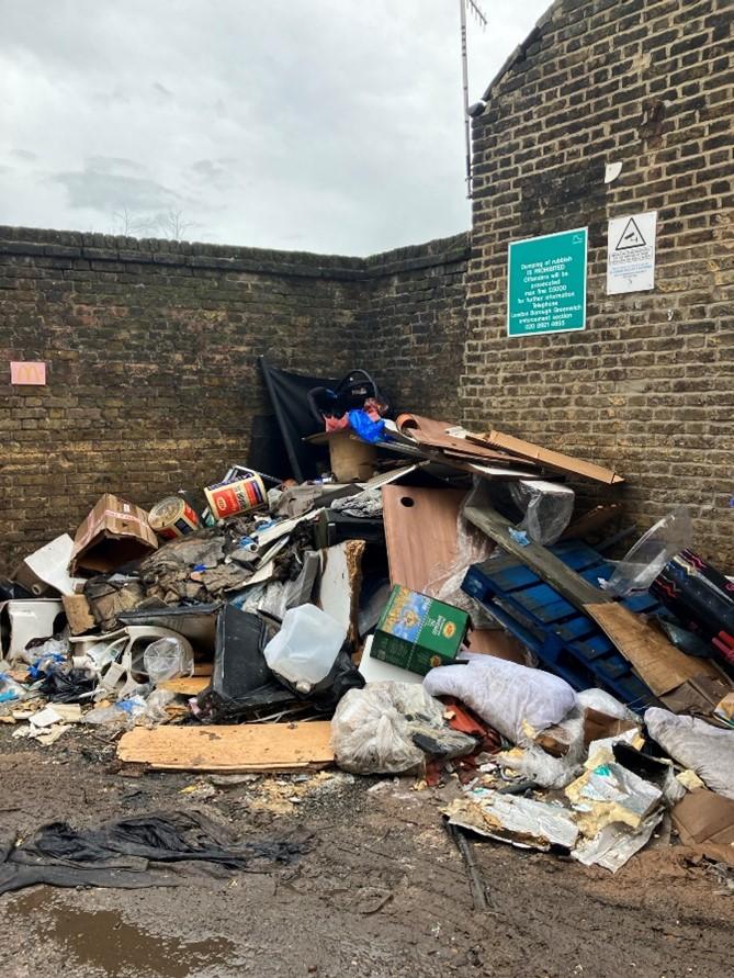 A pile of fly-tipped waste ruining a public place.