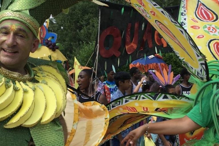 Image of two people dressed in bright green and yellow outfits for Quaggy Festival. The photo was taken in 2019