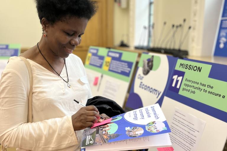 Event attendee with the strategy document on hand, writing suggestions on a post-it note