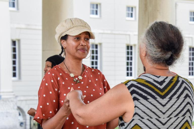 Two people dance in the colonnades outside the Queen's House
