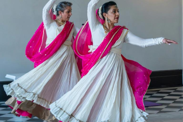Two women in white and pink lehengas dancing