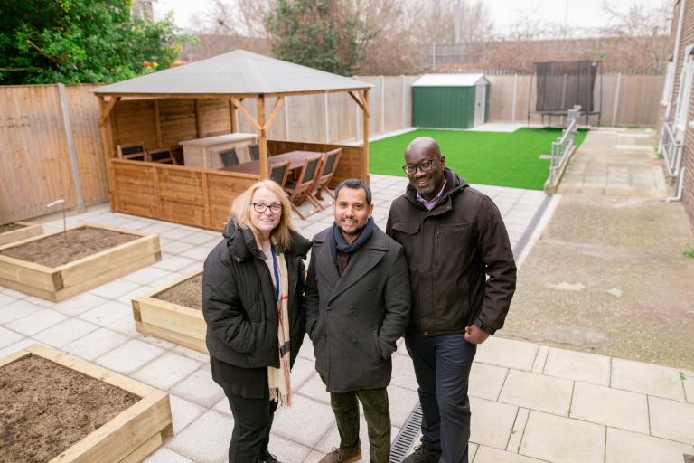Photo showing Cabinet Member for Planning, Estate Renewal and Development Cllr Majid Rahman with care home staff in the upgraded garden.